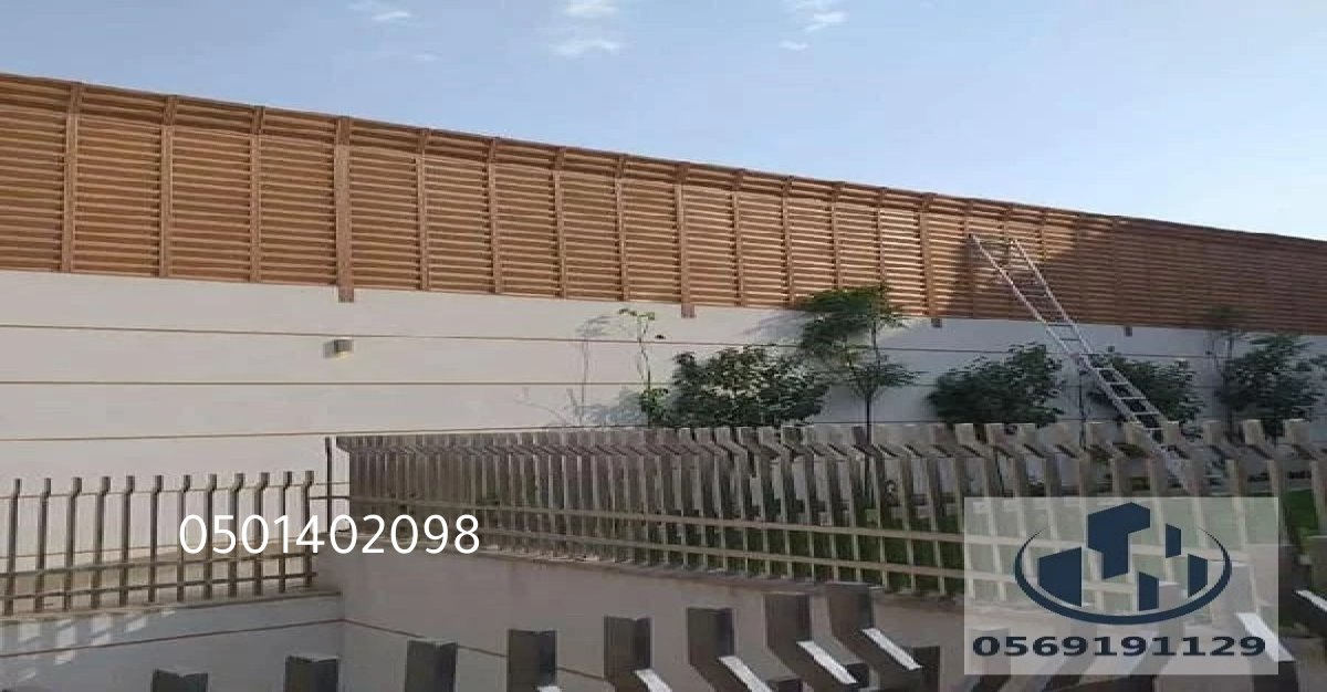 تصميم عصري لساتر خشبي لتقسيم المساحات في الحديقة.